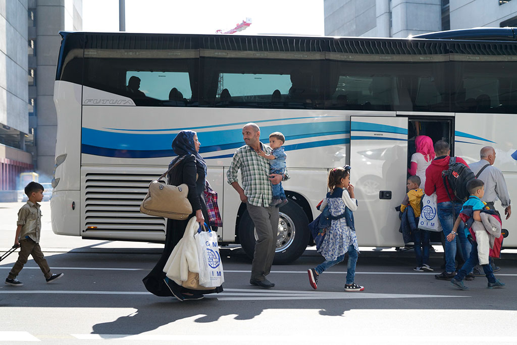 Eine syrische Familie mit drei Kindern besteigt am Flughafen Zürich zusammen mit andern Resettlement-Flüchtlingen einen Bus.